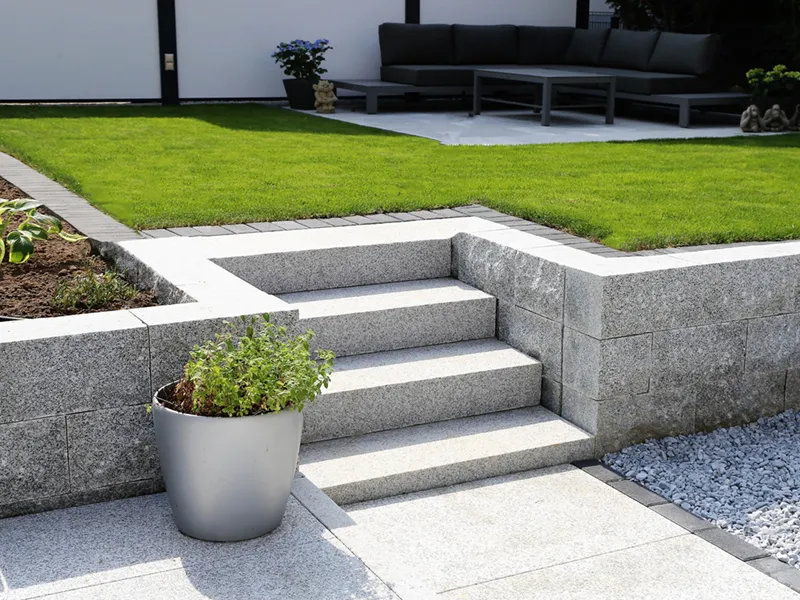 Neat and tidy garden with granite wall and solid block steps
