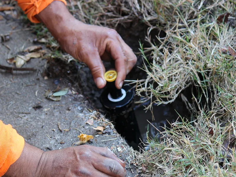 installing a new sprinkler head to replace the old broken sprinkler head